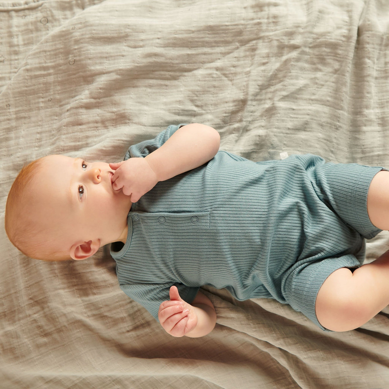Baby in MORI shortleeve ribbed summer sleepsuit, blue